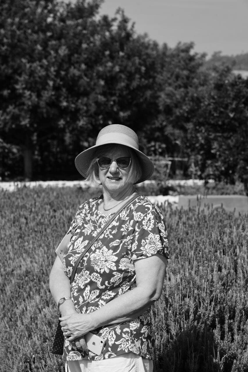 Ann, the maker behind Annmade, in a sun hat standing in a field of lavender
